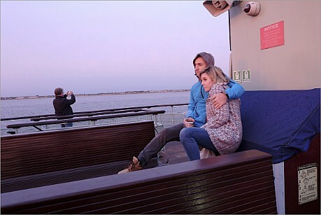 Couple hugging on boat in daylight afterglow.