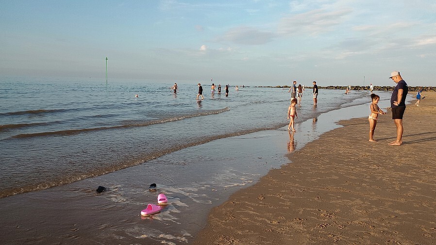 photo of a girl's shoes at the seaside.